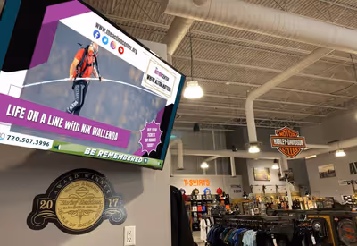 Digital billboard displaying advertising content inside Harley-Davidson retail store